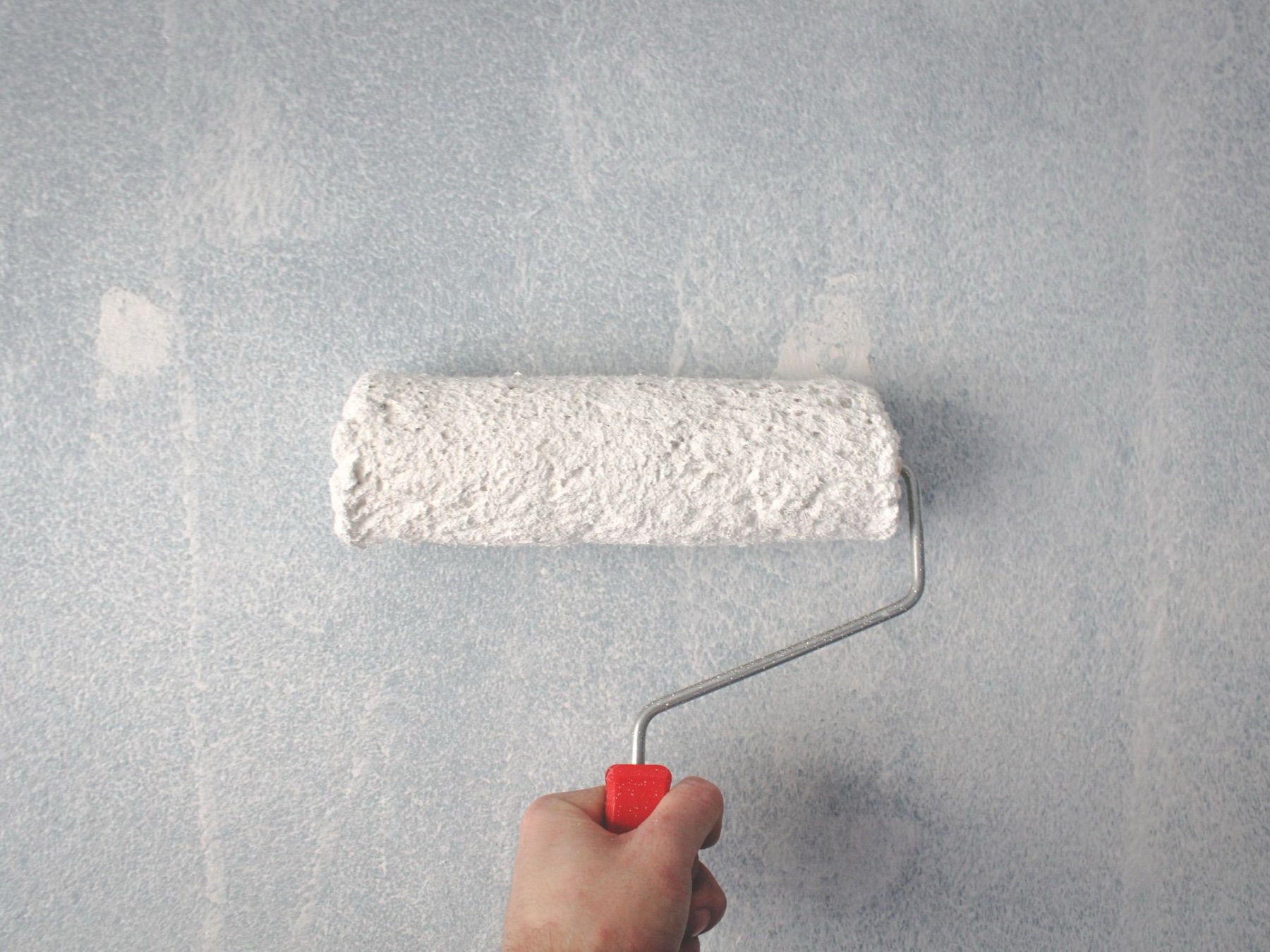 Rolling fresh paint onto an interior wall